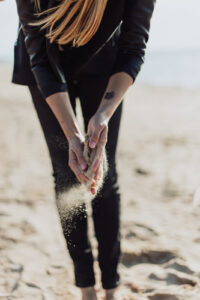 woman letting sand through her fingers